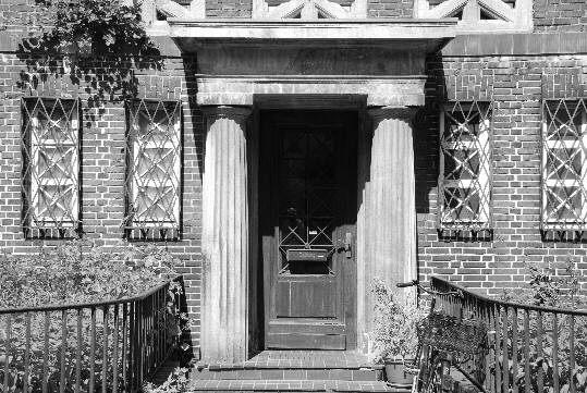 two massive Doric columns to the right and the left of a front door