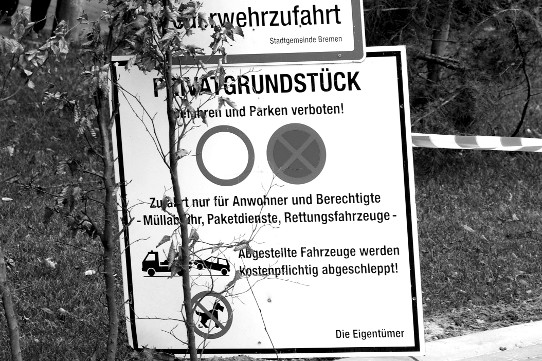 Schild an der Einfahrt zu einer Siedlung mit teuren Villen