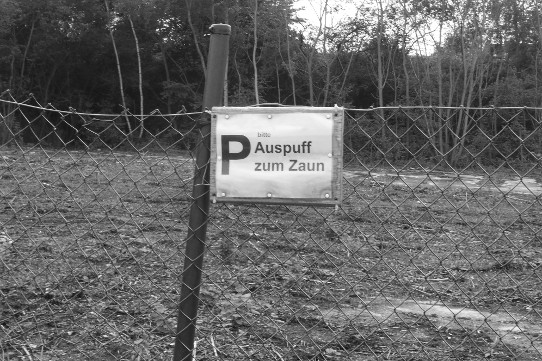 Schild 'P bitte Auspuff zum Zaun'
