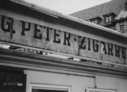 Durch einen Schlitz unter dem Schild konnte ich ein anderes Haus auf der gegen&uuml;berliegenden Stra&szlig;enseite sehen.