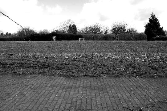 a view from the edge of the riverwalk to the outer embankment slope of the inner dike